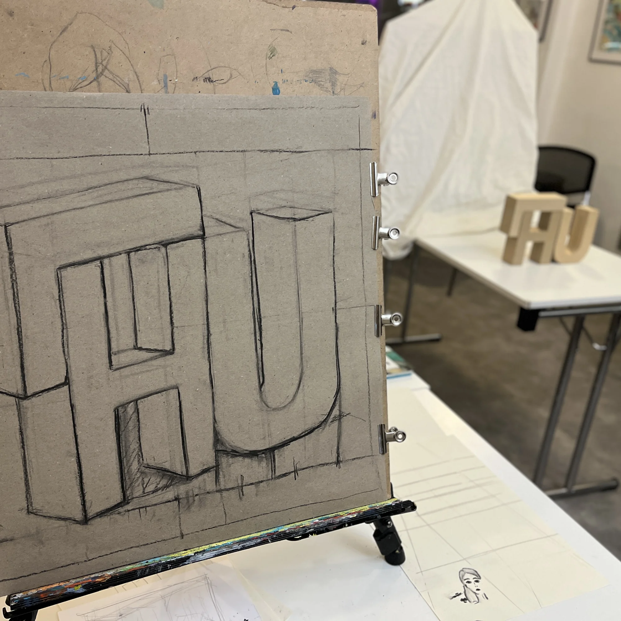 Art class studio with tables, paper, and drawing materials