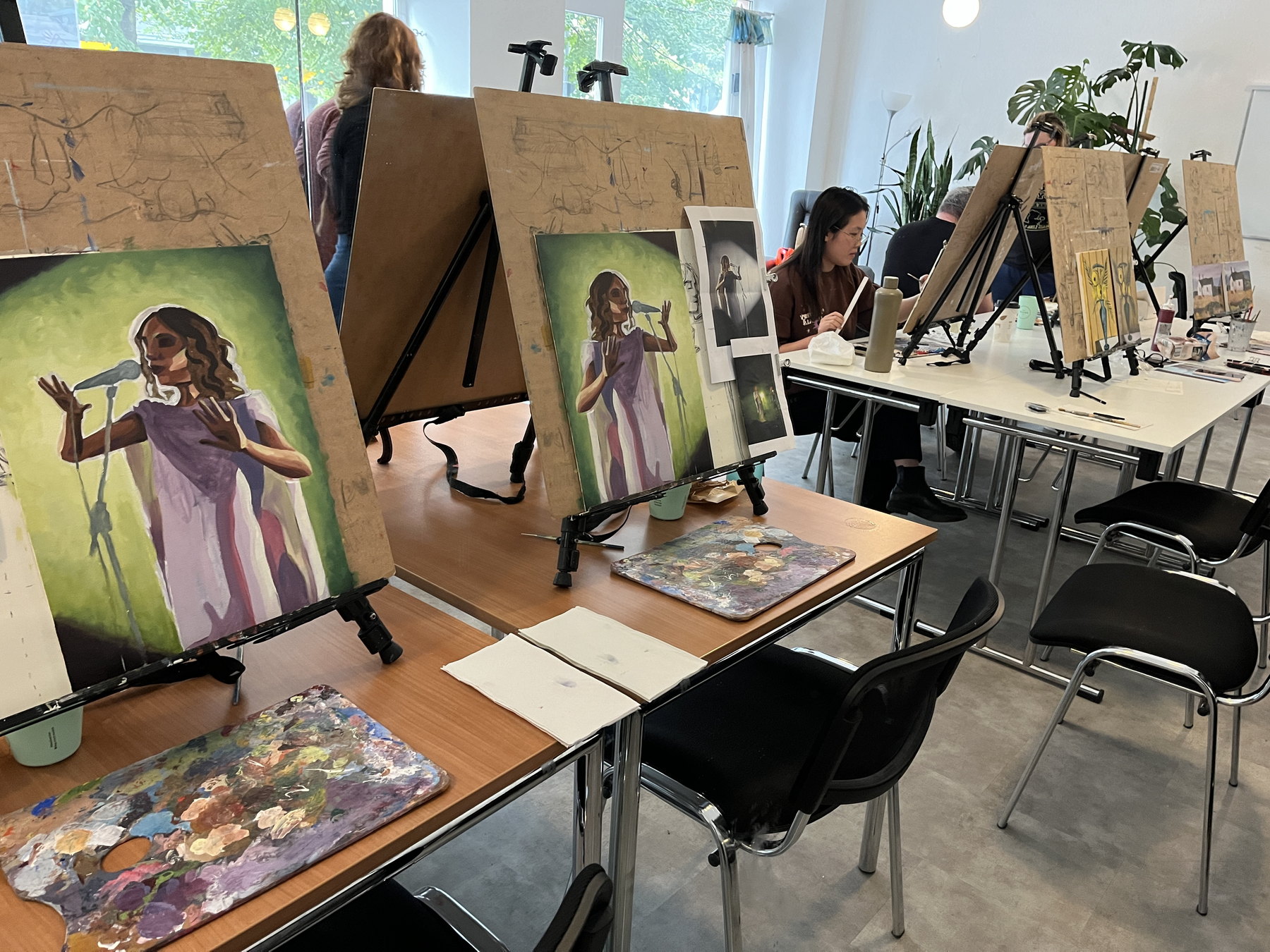 Painting workshop room with finished student paintings and studio tables